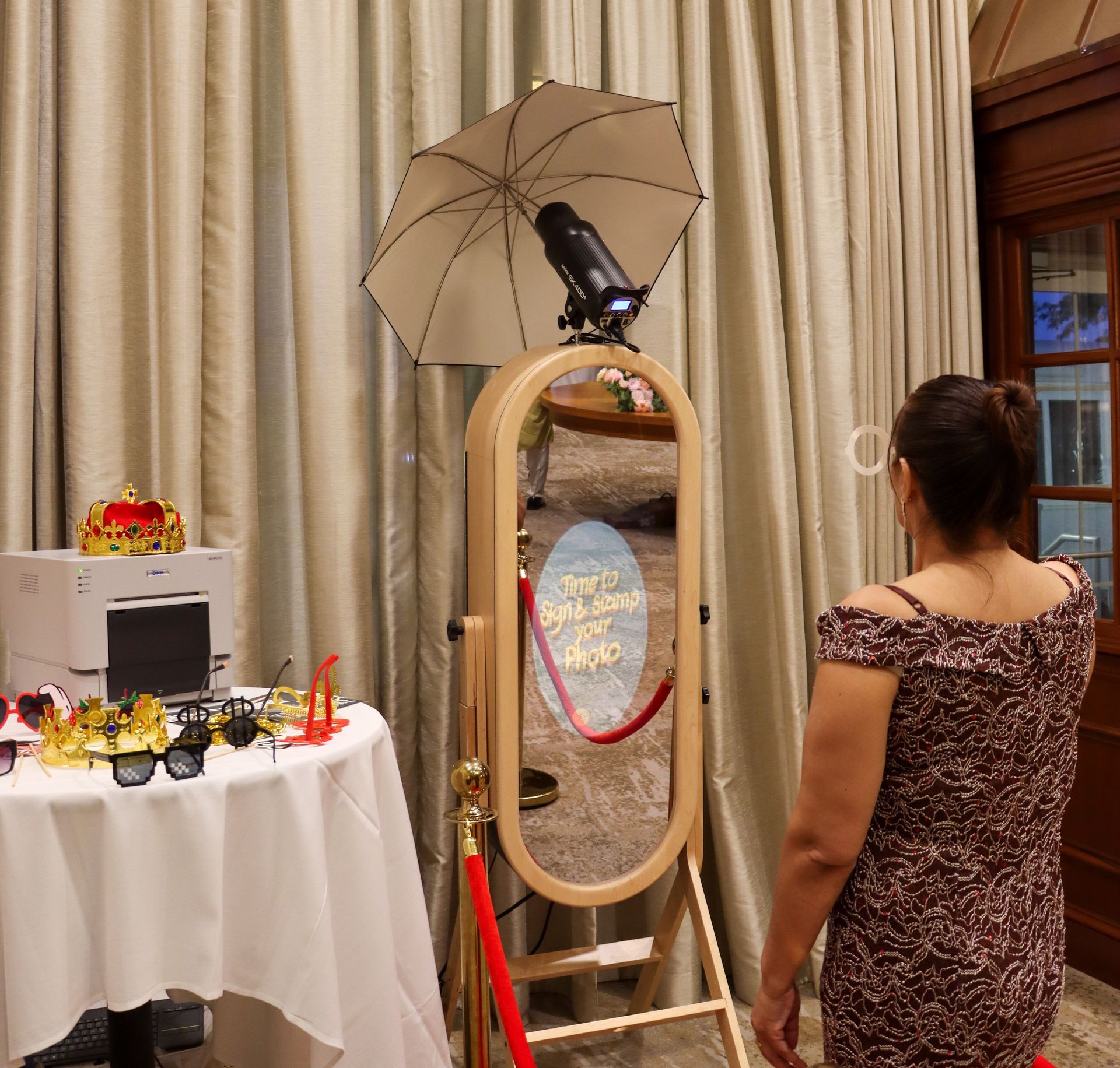 Elegant photo booth setup at formal event with wooden mirror frame